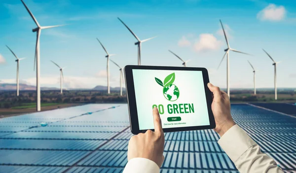 Green business transformation for environment saving and ESG business concept. Businessman using tablet to set corporate goal toward environmental friendly management and alternative clean energy use.