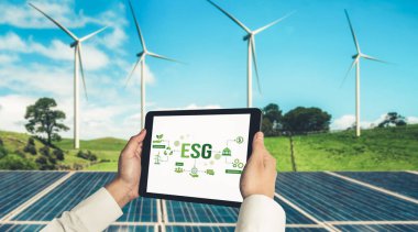 Çevre tasarrufu ve ESG iş konsepti için yeşil iş dönüşümü. İşadamı, çevre dostu yönetime ve alternatif temiz enerji kullanımına yönelik kurumsal bir hedef belirlemek için tablet kullanıyor.