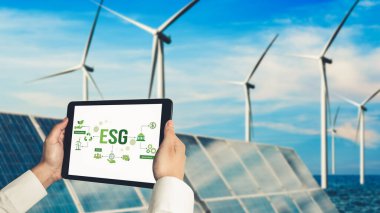 Çevre tasarrufu ve ESG iş konsepti için yeşil iş dönüşümü. İşadamı, çevre dostu yönetime ve alternatif temiz enerji kullanımına yönelik kurumsal bir hedef belirlemek için tablet kullanıyor.