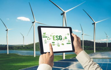 Çevre tasarrufu ve ESG iş konsepti için yeşil iş dönüşümü. İşadamı, çevre dostu yönetime ve alternatif temiz enerji kullanımına yönelik kurumsal bir hedef belirlemek için tablet kullanıyor.