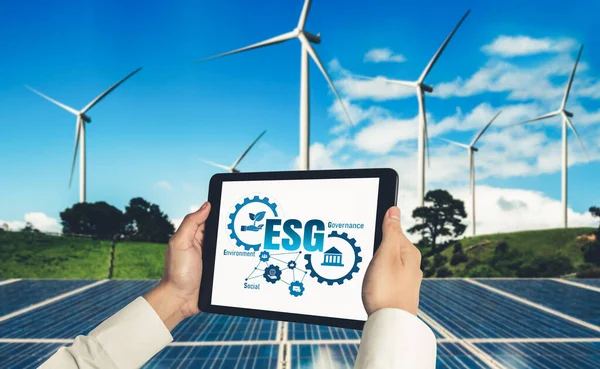 Green business transformation for environment saving and ESG business concept. Businessman using tablet to set corporate goal toward environmental friendly management and alternative clean energy use.