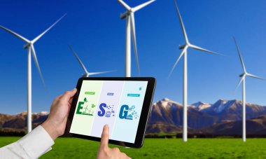 Çevre tasarrufu ve ESG iş konsepti için yeşil iş dönüşümü. İşadamı, çevre dostu yönetime ve alternatif temiz enerji kullanımına yönelik kurumsal bir hedef belirlemek için tablet kullanıyor.