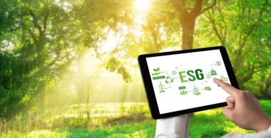 Çevre tasarrufu ve ESG iş konsepti için yeşil iş dönüşümü. İşadamı, çevre dostu yönetime ve alternatif temiz enerji kullanımına yönelik kurumsal bir hedef belirlemek için tablet kullanıyor.