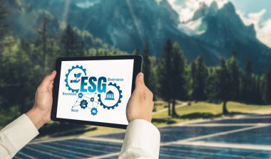 Çevre tasarrufu ve ESG iş konsepti için yeşil iş dönüşümü. İşadamı, çevre dostu yönetime ve alternatif temiz enerji kullanımına yönelik kurumsal bir hedef belirlemek için tablet kullanıyor.