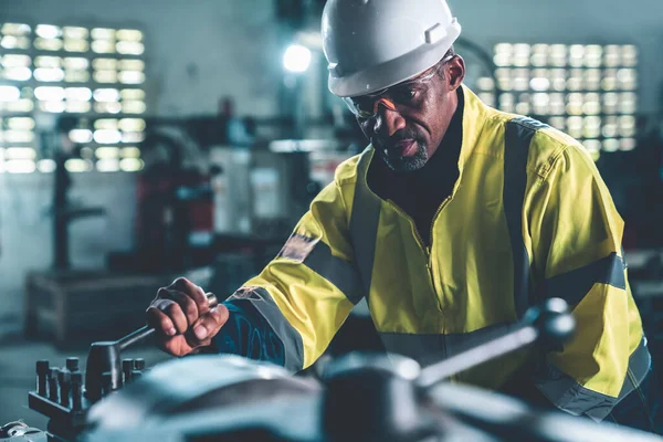 Factory worker or engineer do machine job in adept manufacturing workshop . Industrial people and manufacturing labor concept .