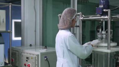 Kimyasal ve biyomedikal deneyler için tedavi laboratuvarında çalışan üniformalı bir kadın bilim adamının portresi.