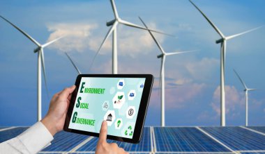 Çevre tasarrufu ve ESG iş konsepti için yeşil iş dönüşümü. İşadamı, çevre dostu yönetime ve alternatif temiz enerji kullanımına yönelik kurumsal bir hedef belirlemek için tablet kullanıyor.