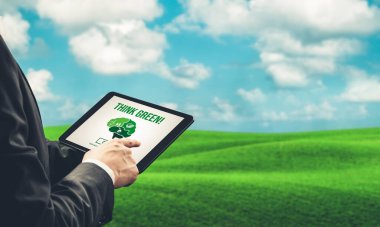 Çevre tasarrufu ve ESG iş konsepti için yeşil iş dönüşümü. İşadamı, çevre dostu yönetime ve alternatif temiz enerji kullanımına yönelik kurumsal bir hedef belirlemek için tablet kullanıyor.