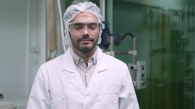 Kimyasal ve biyomedikal deneyler için tedavi laboratuvarında çalışan üniformalı bir bilim adamının portresi.