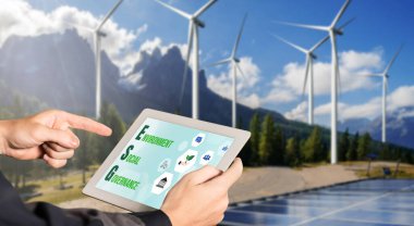 Çevre tasarrufu ve ESG iş konsepti için yeşil iş dönüşümü. İşadamı, çevre dostu yönetime ve alternatif temiz enerji kullanımına yönelik kurumsal bir hedef belirlemek için tablet kullanıyor.