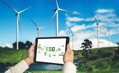 Çevre tasarrufu ve ESG iş konsepti için yeşil iş dönüşümü. İşadamı, çevre dostu yönetime ve alternatif temiz enerji kullanımına yönelik kurumsal bir hedef belirlemek için tablet kullanıyor.