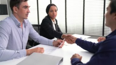 Commercial contract signed by competent people of various ethnicities and shake hands. Trade agreements, two-party business transactions.