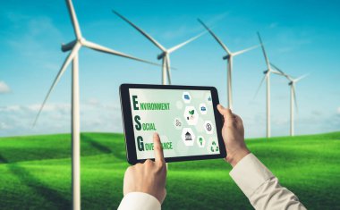 Çevre tasarrufu ve ESG iş konsepti için yeşil iş dönüşümü. İşadamı, çevre dostu yönetime ve alternatif temiz enerji kullanımına yönelik kurumsal bir hedef belirlemek için tablet kullanıyor.