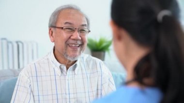 A young female doctor inquires about personal information of a contented senior at home. Medical care for the elderly, elderly illness, and nursing homes, home care.