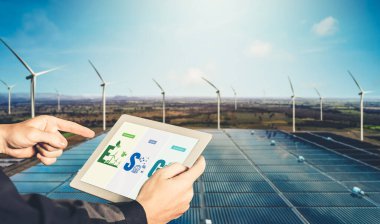 Çevre tasarrufu ve ESG iş konsepti için yeşil iş dönüşümü. İşadamı, çevre dostu yönetime ve alternatif temiz enerji kullanımına yönelik kurumsal bir hedef belirlemek için tablet kullanıyor.