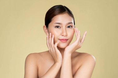 Portrait of ardent young woman with healthy clear skin and soft makeup looking at camera and posing beauty gesture. Cosmetology skincare and beauty concept.