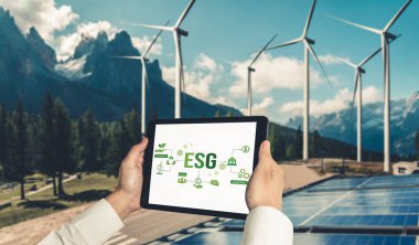Çevre tasarrufu ve ESG iş konsepti için yeşil iş dönüşümü. İşadamı, çevre dostu yönetime ve alternatif temiz enerji kullanımına yönelik kurumsal bir hedef belirlemek için tablet kullanıyor.