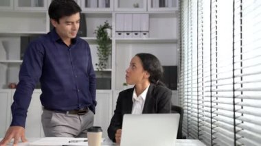 Concept of experienced and competent coworker, employer, supervisor giving advice to a young female office worker. Teamwork between coworkers, leadership company, multiracial in workspace.