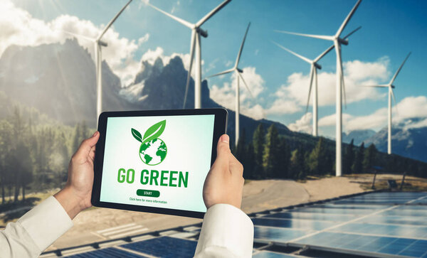 Green business transformation for environment saving and ESG business concept. Businessman using tablet to set corporate goal toward environmental friendly management and alternative clean energy use.