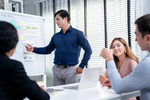 Competent office workers from various nationalities are debating, discussing and brainstorming in the meeting room. A group of employees is collaborating to achieve their business objectives.