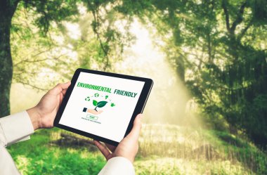 Çevre tasarrufu ve ESG iş konsepti için yeşil iş dönüşümü. İşadamı, çevre dostu yönetime ve alternatif temiz enerji kullanımına yönelik kurumsal bir hedef belirlemek için tablet kullanıyor.