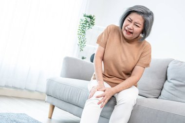 An agonizing elderly woman is experiencing chest pain. Medical attention, medical service for seniors.