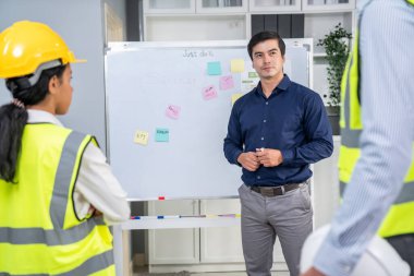 A team of investor and competent engineers brainstorming on the whiteboard to find new ideas and making plans. The idea of a team gather ideas together.