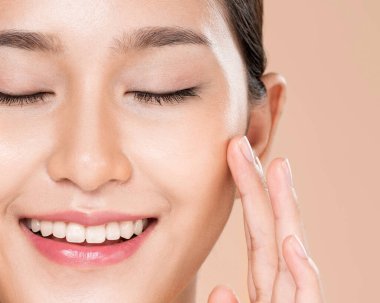 Closeup ardent young woman with healthy clear skin and soft makeup looking at camera and posing beauty gesture. Cosmetology skincare and beauty concept.