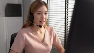 Competent female operator working on computer and while talking with clients. Concept relevant to both call centers and customer service offices.