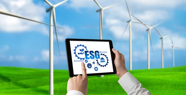 Green business transformation for environment saving and ESG business concept. Businessman using tablet to set corporate goal toward environmental friendly management and alternative clean energy use.