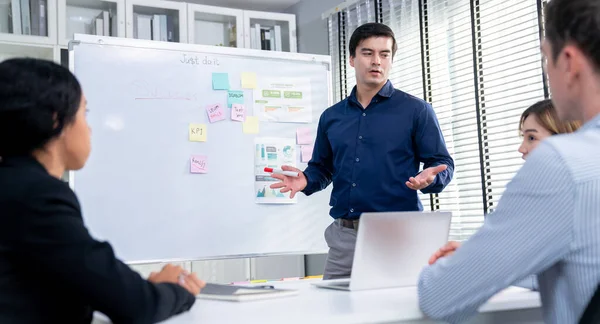 Competent office workers from various nationalities are debating, discussing and brainstorming in the meeting room. A group of employees is collaborating to achieve their business objectives.