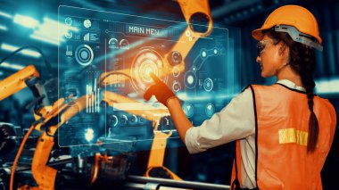 Engineer use cybernated robotic software to control industry robot arm in factory . Automation manufacturing process controlled by specialist using IOT software connected to internet network .