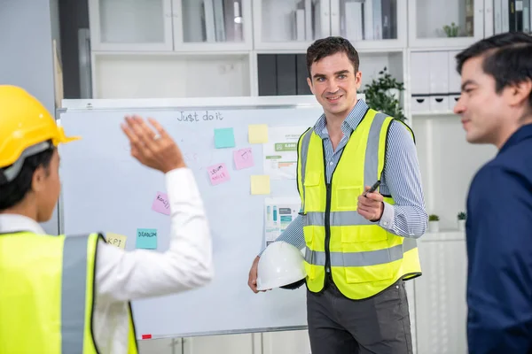 Entrepreneur brainstorming ideas with his competent engineers in the office. Architectural investors and engineers working on an upcoming project in a fun and friendly environment.