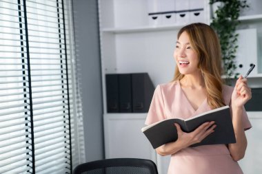 Young competent office lady, intern, secretary holding a log in office room. Concept of various career for office working. Concept of diverse office careers.