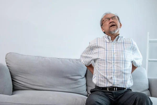 Agonizing Senior Man Need Assistance While Sitting His Sofa Home — Stockfoto