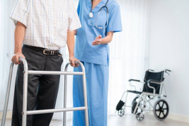 Physiotherapist assists her contented senior patient on folding walker. Recuperation for elderly, seniors care, nursing home.