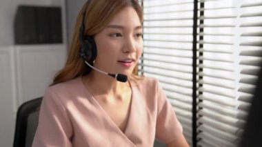 Competent female operator working on computer and while talking with clients. Concept relevant to both call centers and customer service offices.