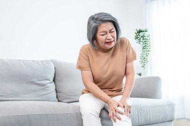 An agonizing elderly woman is experiencing chest pain. Medical attention, medical service for seniors.