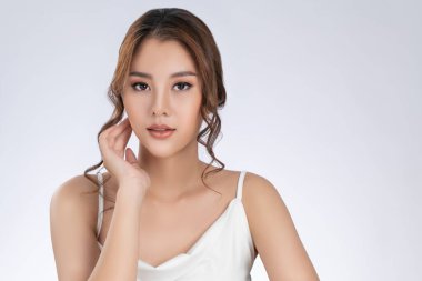 Portrait of gorgeous young girl posing beauty gesture with healthy clear skin and soft makeup. Cosmetology and beauty concept.