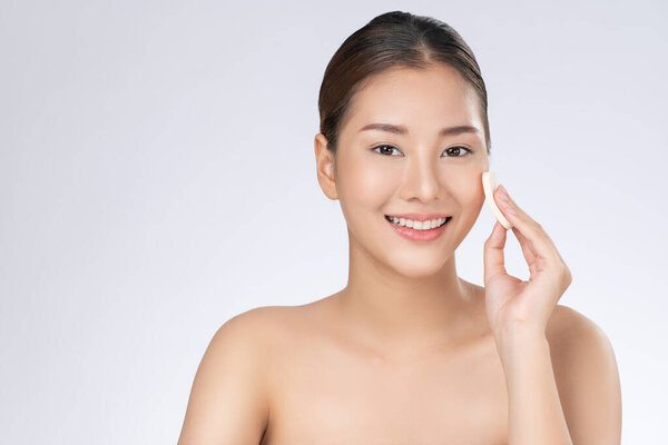 Gorgeous woman applying her cheek with dry powder. Portrait of younger with perfect makeup and healthy skin concept.