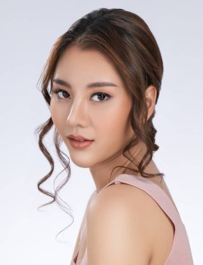 Close up gorgeous young girl posing beauty gesture with healthy clear skin and soft makeup. Cosmetology and beauty concept.