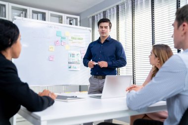 Competent office workers from various nationalities are debating, discussing and brainstorming in the meeting room. A group of employees is collaborating to achieve their business objectives.