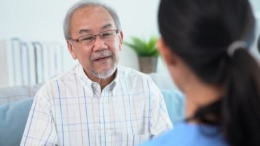 A young female doctor inquires about personal information of a contented senior at home. Medical care for the elderly, elderly illness, and nursing homes, home care.