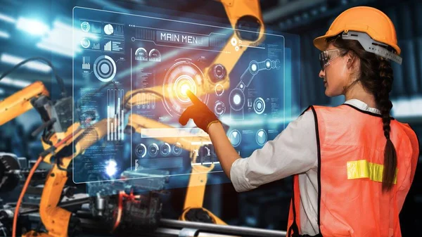 Engineer use cybernated robotic software to control industry robot arm in factory . Automation manufacturing process controlled by specialist using IOT software connected to internet network .