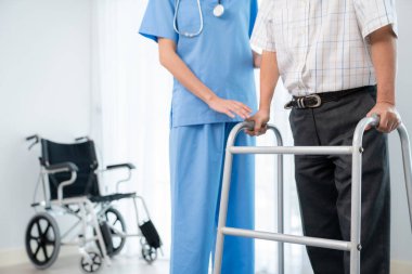 Physiotherapist assists her contented senior patient on folding walker. Recuperation for elderly, seniors care, nursing home.
