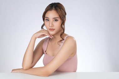 Portrait of gorgeous young girl posing beauty gesture with healthy clear skin and soft makeup. Cosmetology and beauty concept.