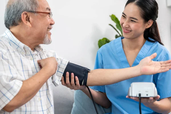 Contented Retired Man Having Blood Pressure Check His Personal Caregiver — Stockfoto