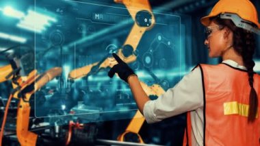 Engineer use cybernated robotic software to control industry robot arm in factory . Automation manufacturing process controlled by specialist using IOT software connected to internet network .