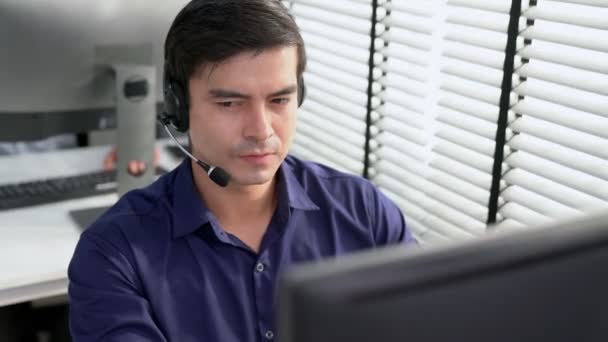 Young Competent Asian Male Call Center Agent Working His Computer — Stock videók