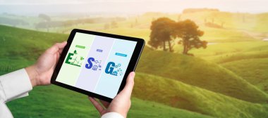 Çevre tasarrufu ve ESG iş konsepti için yeşil iş dönüşümü. İşadamı, çevre dostu yönetime ve alternatif temiz enerji kullanımına yönelik kurumsal bir hedef belirlemek için tablet kullanıyor.